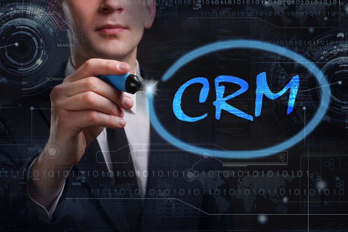 Business, Technology, Internet and network concept. Young business man writing word: CRM 